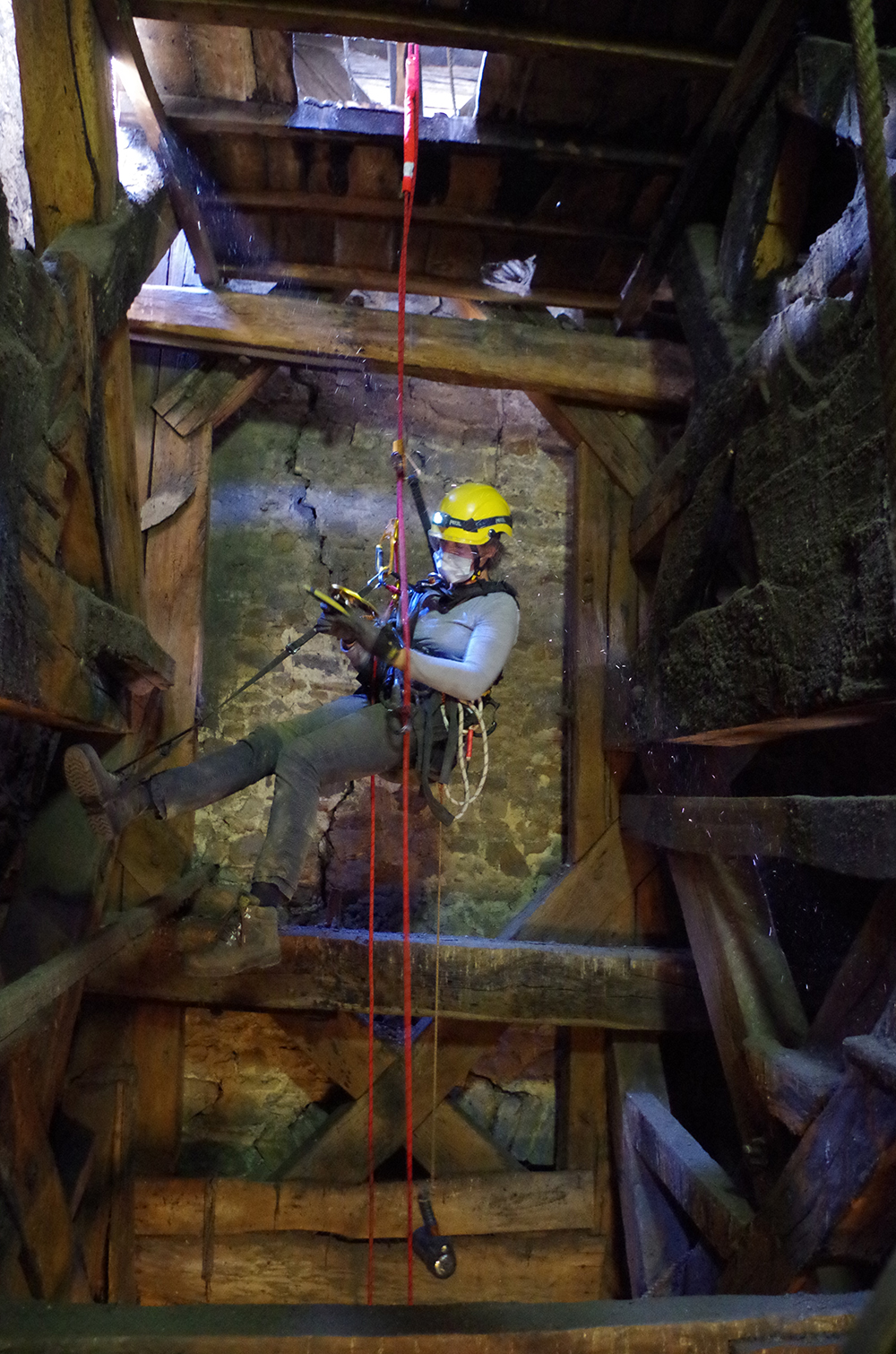 5. Accès aux bois d’un beffroi par cordes. Ici, Sarah Cremer dans le beffroi de la collégiale Saint- Jean à Liège pour l’AWAP © photo de travail, KIK-IRPA.